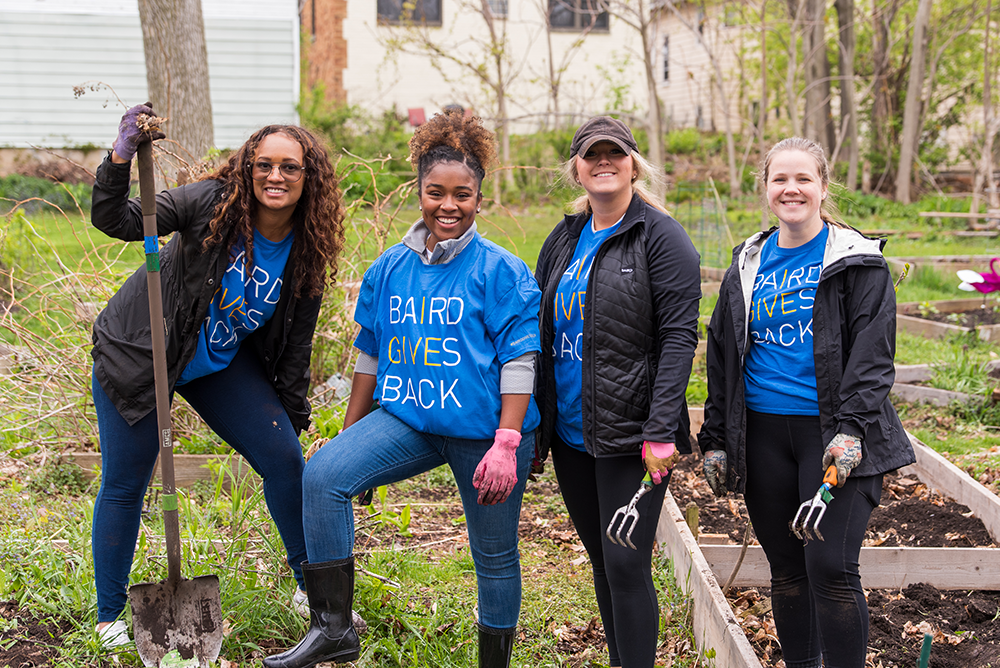 Four RJF Pro associates working in an outdoor garden while volunteering.