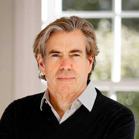 Professional headshot of Tim Byrne wearing a suit but no tie.
